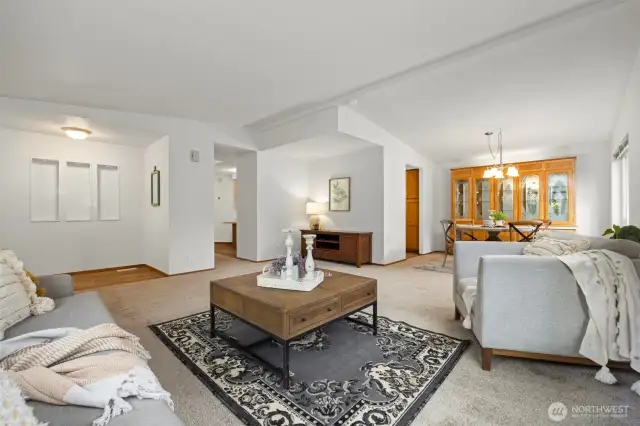 View of the front door entry area, primary living room and dining room.