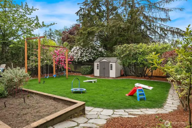 Storage shed for yard games and garden tools plus a raised bed.