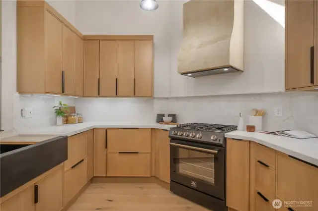 Quartz counters that boast full backsplash, cooking ledge and waterfall edge.