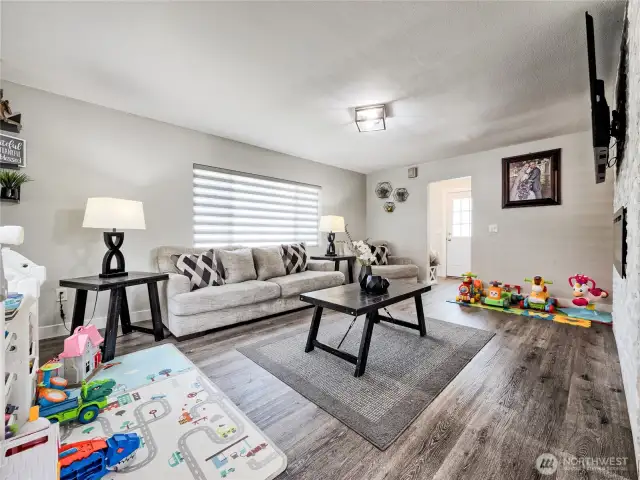 Spacious living room with hardwood floors and natural light