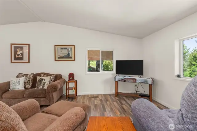 The living room offers vaulted ceilings, beautiful light, and scenic views—perfect for relaxing or entertaining.