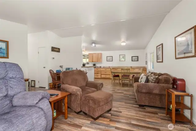 Open dining area flows seamlessly from the kitchen into the living room with views of the natural surroundings.