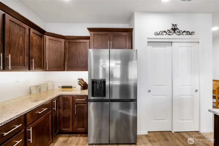 The large refrigerator is handy, standing right next to the food pantry.