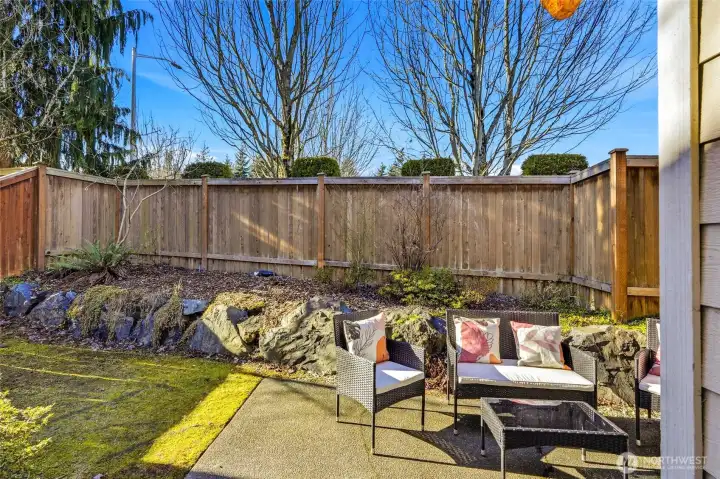 Fully fenced backyard with patio area.