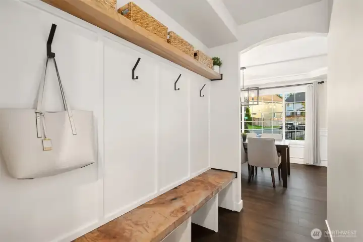 This custom mudroom welcomes you home when entering from the garage. It's statement wood bench and accents offer both visual intrigue and practical functionality.