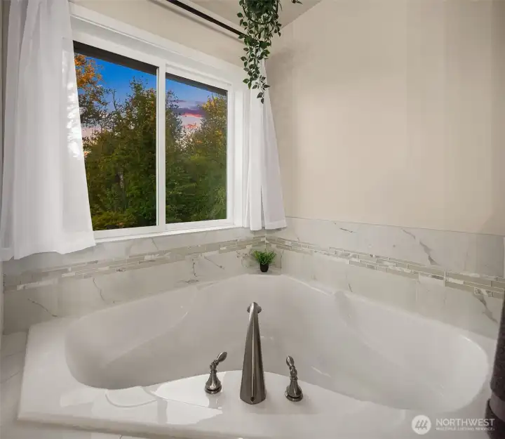 In the corner lies an ergonomically designed soaking tub with gorgeous nature views just a glance away.