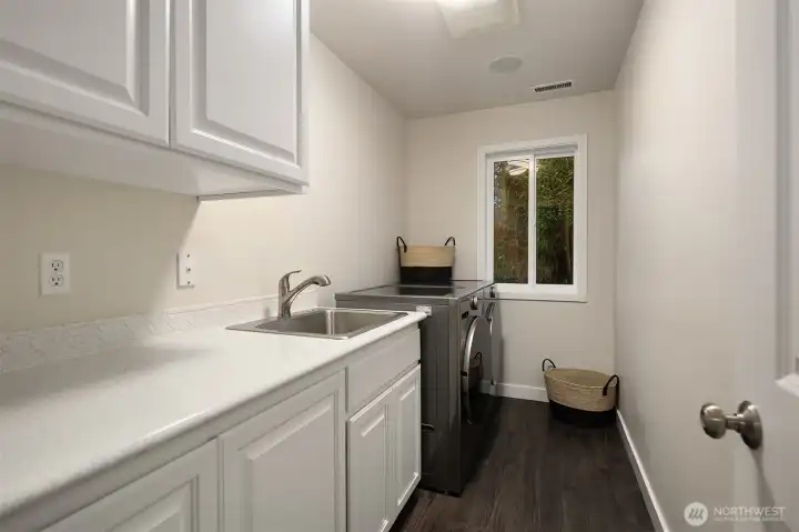 The laundry room is conveniently located upstairs and has a large sink basin, as well as both electric and gas dryer hook ups.
