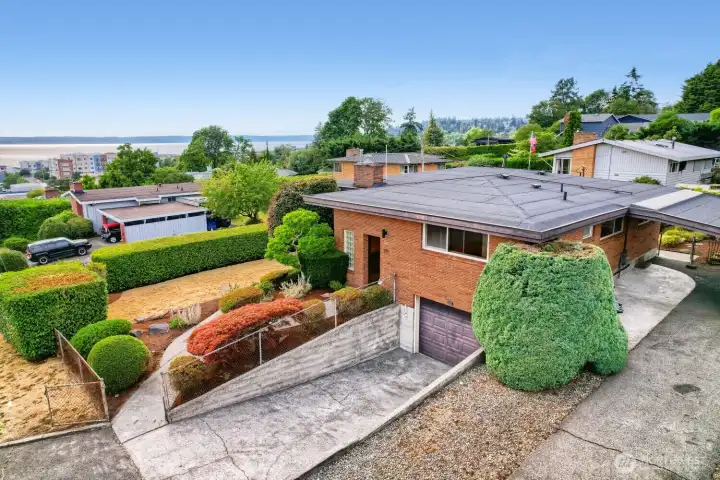Mid-Century Home with Puget Sound Views This beautifully maintained mid-century residence offers timeless design and exceptional curb appeal. The brick exterior, clean rooflines, and large picture windows showcase classic architectural character, while manicured landscaping and sculpted hedges frame the home perfectly. Set on an elevated lot with views of Puget Sound, the property features a private driveway, attached garage, and lush garden spaces that blend elegance with Northwest charm. Mid-Century Home with Puget Sound Views This beautifully maintained mid-century residence offers timeless design and exceptional curb appeal. The brick exterior, clean rooflines, and large picture windows showcase classic architectural character, while manicured landscaping and sculpted hedges frame the home perfectly. Set on an elevated lot with views of Puget Sound, the property features a private driveway, attached garage, and lush garden spaces that blend elegance with Northwest charm.