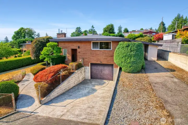 Front Exterior with Ample Parking and Expansive Views This mid-century brick home offers timeless curb appeal and a welcoming approach framed by manicured landscaping. The attached garage provides convenient parking and storage, while mature shrubs and colorful plantings add texture and charm. Elevated positioning captures sweeping views of Puget Sound and the surrounding neighborhood—a perfect blend of classic architecture and Northwest scenery. Front Exterior with Ample Parking and Expansive Views This mid-century brick home offers timeless curb appeal and a welcoming approach framed by manicured landscaping. The attached garage provides convenient parking and storage, while mature shrubs and colorful plantings add texture and charm. Elevated positioning captures sweeping views of Puget Sound and the surrounding neighborhood—a perfect blend of classic architecture and Northwest scenery.