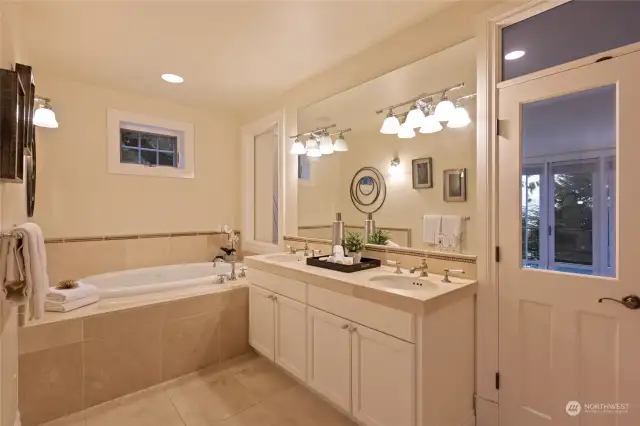 Primary suite bath with double vanities, jetted tub and walk-in shower.