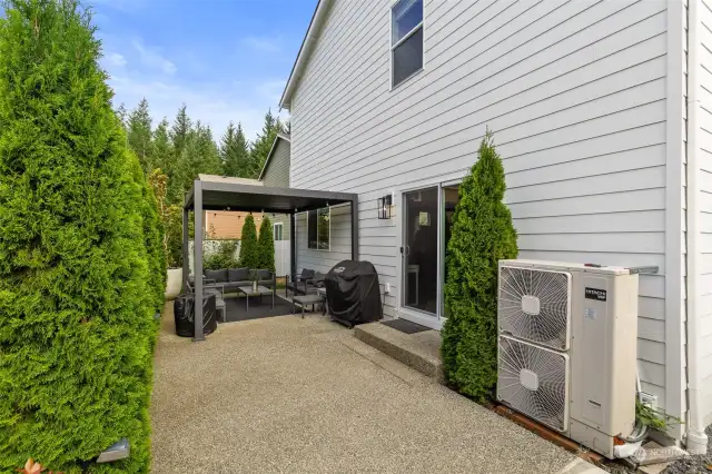 Rain or shine this low-maintenance backyard designed for effortless outdoor living. This extended patio space is perfect for those who love to entertain. In addition, the home is equipped with a 90+ efficient heat pump, offering energy-saving comfort throughout the year. With direct access from the sliding door off the main living area, this outdoor space is both functional and inviting—a perfect blend of style, convenience, and eco-friendly living.