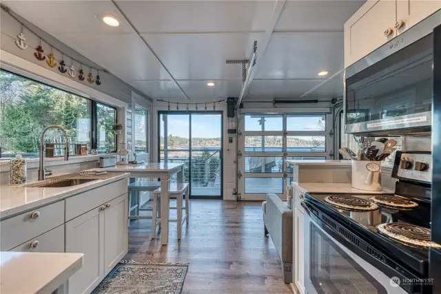 Upper level kitchen with views to deck and water.  Roll up door to the right provides indoor outdoor living space