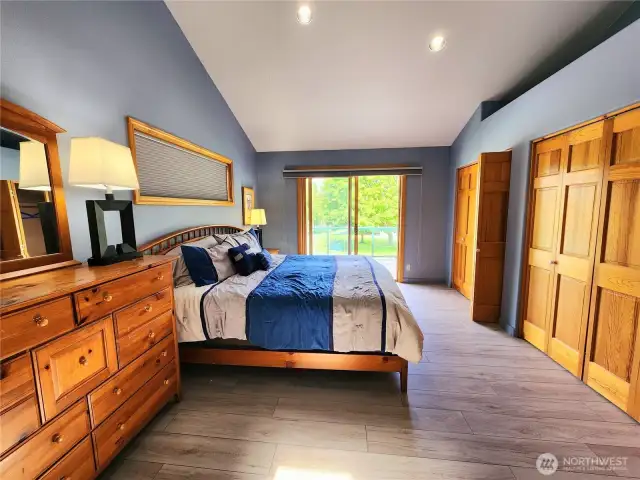 Main level primary bedroom with sliding glass door onto the deck.