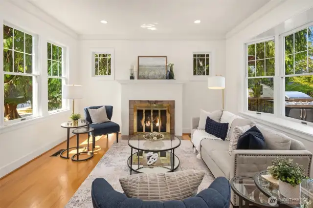 Sunlit living room surrounded by windows and filled with natural light