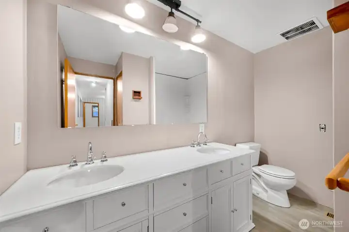 Lower level full bathroom with new vanity, sinks and and flooring.
