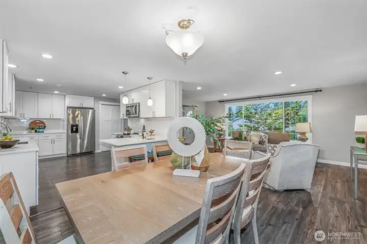 The open layout creates a seamless connection between the kitchen, dining, and living areas. This central hub of the home is perfect for entertaining or enjoying everyday life in a light-filled setting.