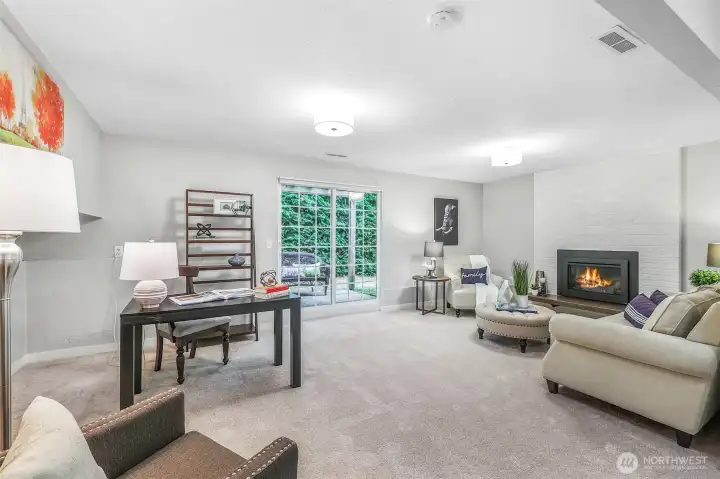 The lower-level family room provides a versatile gathering space with direct access to the backyard. A cozy fireplace adds warmth and ambiance, making it a welcoming spot year-round.