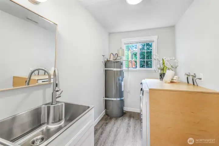 The laundry room is well-equipped with a utility sink, counter space, and natural light. Its practical layout makes household tasks more convenient.