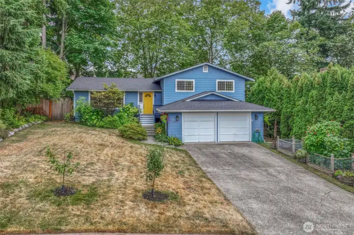 The wide driveway and attached two-car garage provide ample parking and convenience. The front yard offers established landscaping, a perfect canvas to add your own touches.