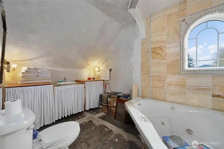 The upstairs bathroom.  Additional onyx tile is stacked up and ready for the next owner. The jetted tub is partially plumbed in.