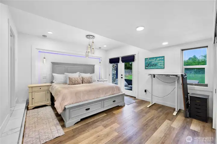 Light and bright primary bedroom with custom lighting and new french doors for private access to new deck