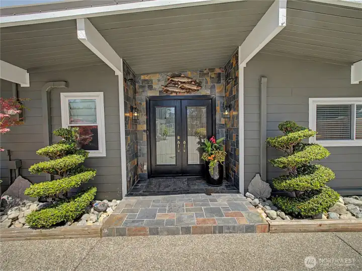 A striking custom entry sets the tone for the quality found throughout the home. Rich stonework, elegant double doors, and meticulously maintained landscaping create a warm and unforgettable first impression.
