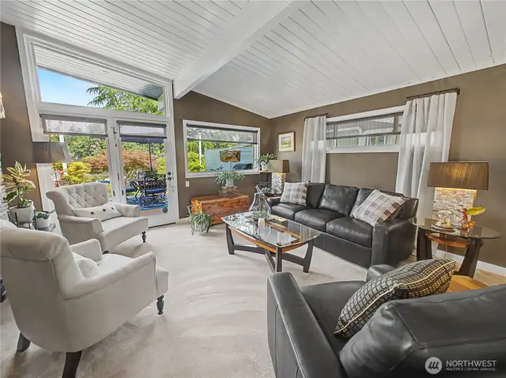 Vaulted ceilings, abundant natural light, and expansive windows create a bright and inviting living space. French doors open seamlessly to the outdoor entertaining areas, blending indoor comfort with the beauty of the surrounding landscape.