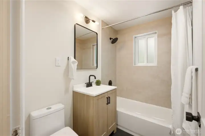 The full bathroom has been recently refreshed with a new tile tub surround, new vanity, new toilet and new fixtures and lighting fixture.