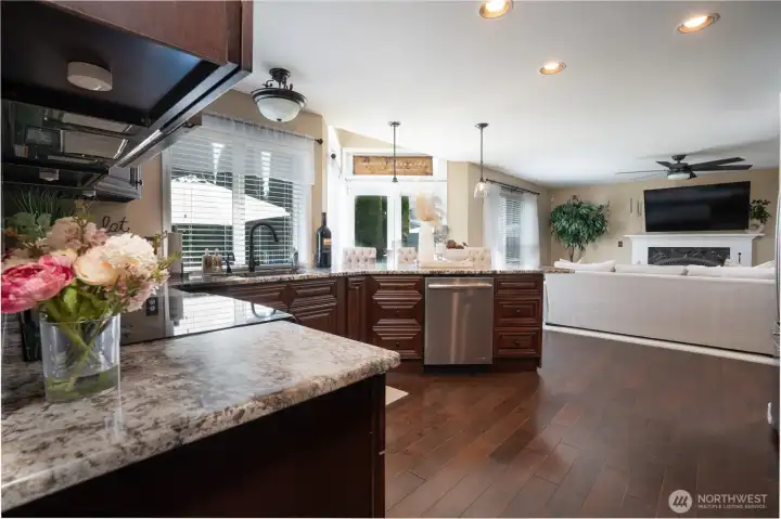 Granite, rich dark cabinets, and wood floors with stainless appliances welcome you in your new kitchen. This kitchen has been host to many awesome gatherings and memory making times.