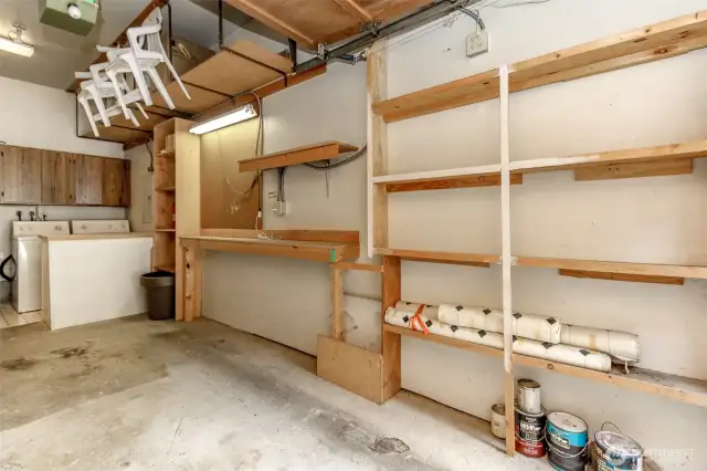 Lots of storage shelves in garage plus w work bench with extra lighting!