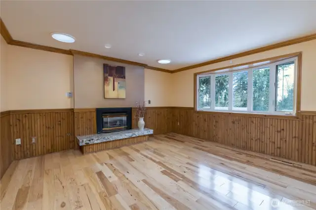 Living room has gas fireplace, skylights, gorgeous hardwood floor