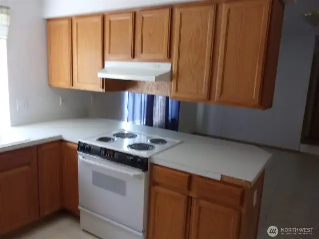 Kitchen has range/oven and oak cabinets.