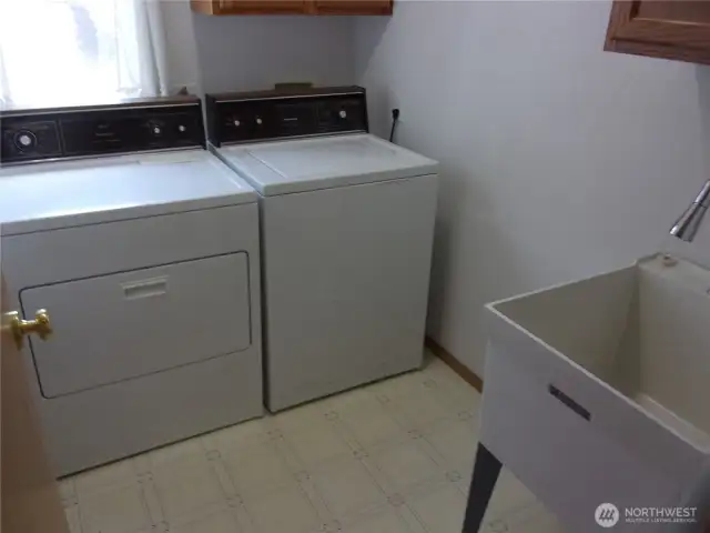 Laundry room includes washer, dryer, and utility tub.