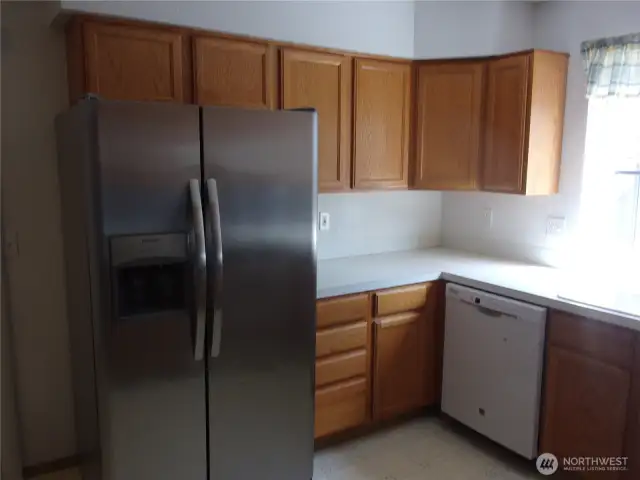 Large side-by-side refrigerator and dishwasher add utility to the kitchen.