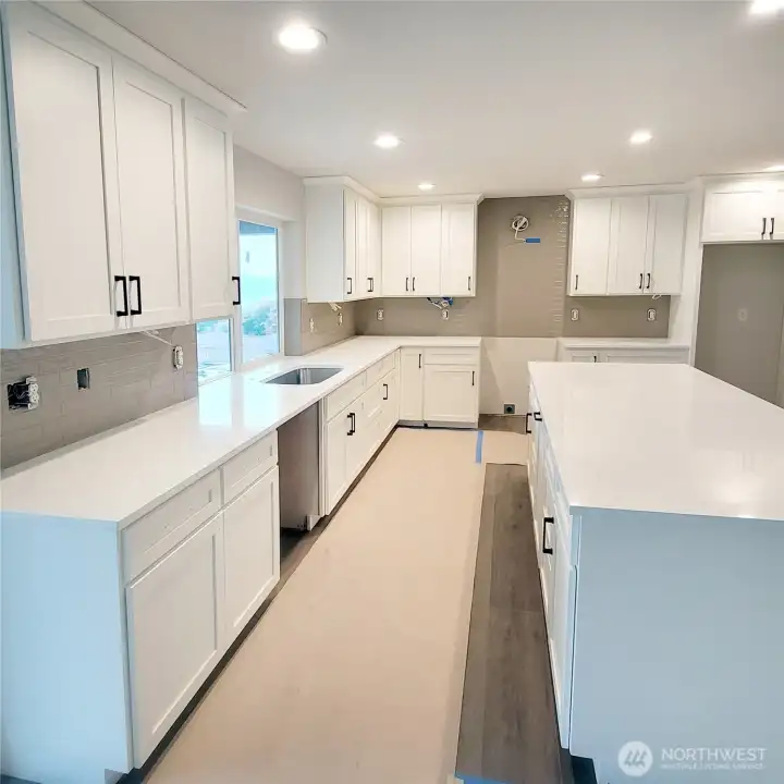 Light & bright kitchen with quartz countertops, full tile back splash.