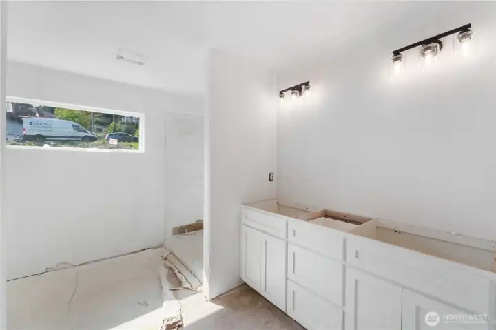 Full primary bath with double vanity, walk in tile shower.