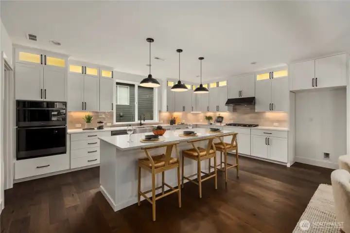 Kitchen: Expansive chef’s kitchen features quartz countertops, oversized island with seating, and full-height cabinetry with display transoms for added style and storage. Stainless steel appliances, pendant lighting, and a walk-in pantry create the perfect balance of form and function for everyday living or entertaining.    Photos are from a previous Glacier model home at Foxmoore and are for visualization purposes only - colors, selections, and included feature can and will vary.