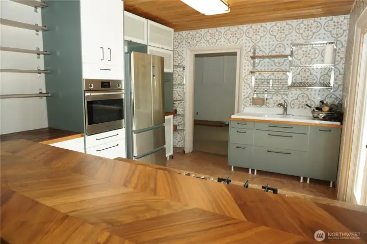 Kitchen with tile walls, wood countertops and French doors to the outside.