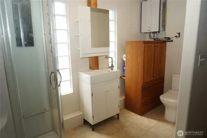 Shower, sink, toilet off the main bedroom with a second door to the backyard. Newer on demand natural gas hot water tankless system.