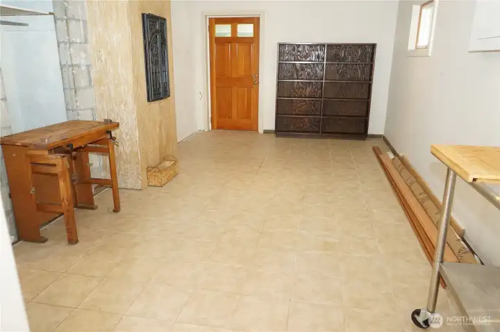 Main bedroom with a gas fireplace, door to access the backyard. Tile floors.
