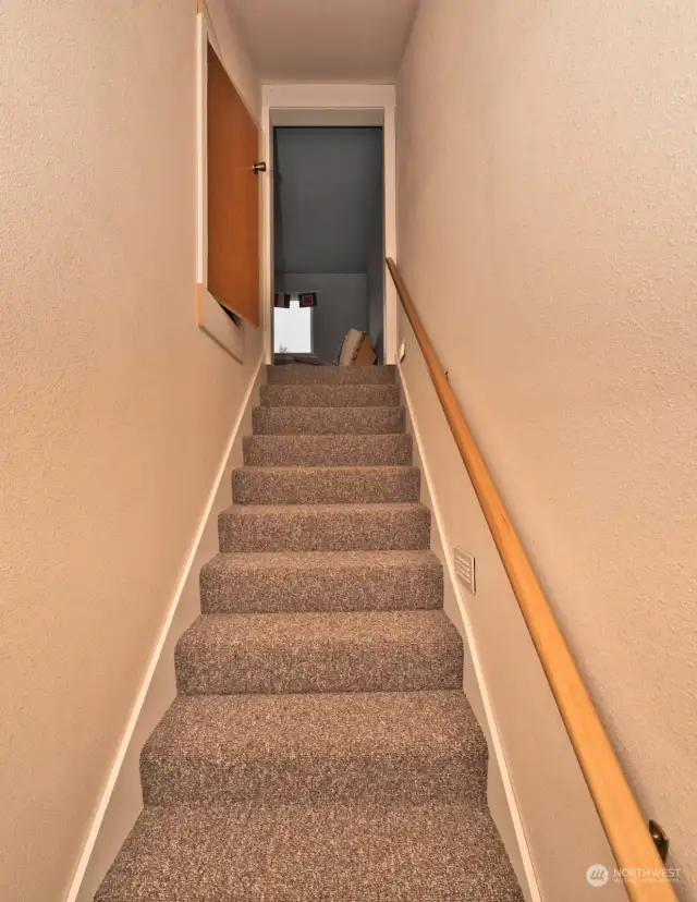 Stairway to the second floor. Note the door to an attic for additional storage.