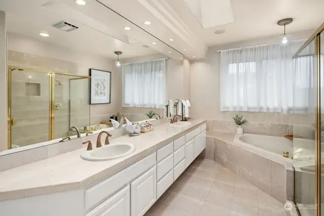 Primary Suite 5 piece bathroom offers marble floors and counters.