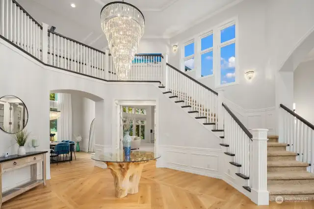 Breathtaking two-story entryway foyer features NEW elegant chandeliers & wide-plank hardwood floors.