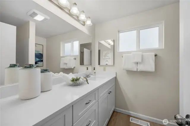 Main bathroom with new vanity, quartz counter, lighting, LVP floor and paint.