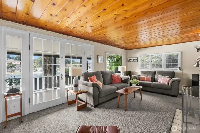The comfortable living room offers harbor views and opens to the outdoors through classic French doors.