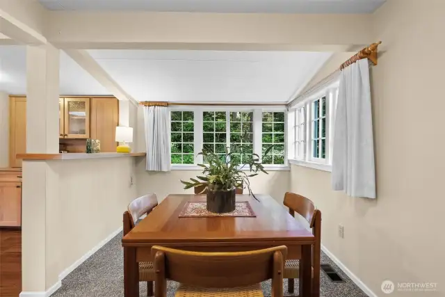 Gaze out to a private yard filled with lush green foliage and mature pines surrounding the home.