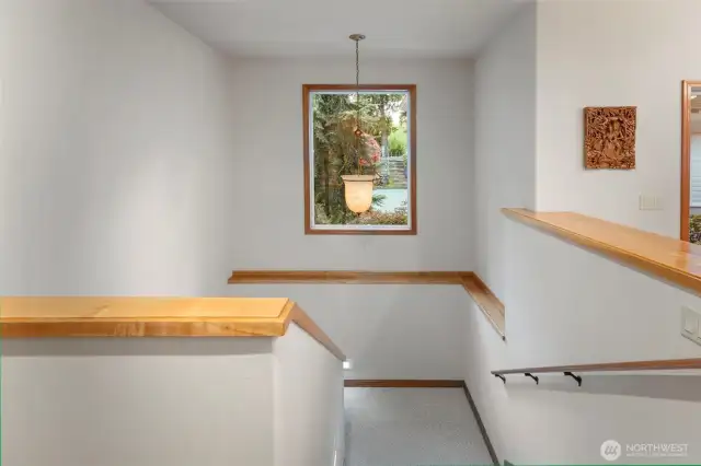Spacious stairway to Lower level of home featuring side lights.