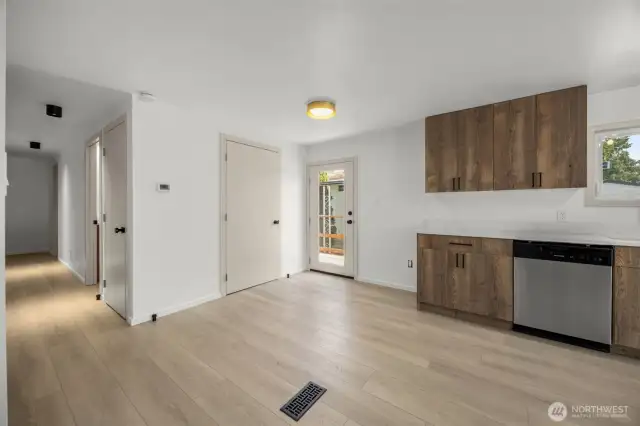 North end of kitchen. Glass door leads out to the back deck. Closed door adjacent to glass door is laundry closet