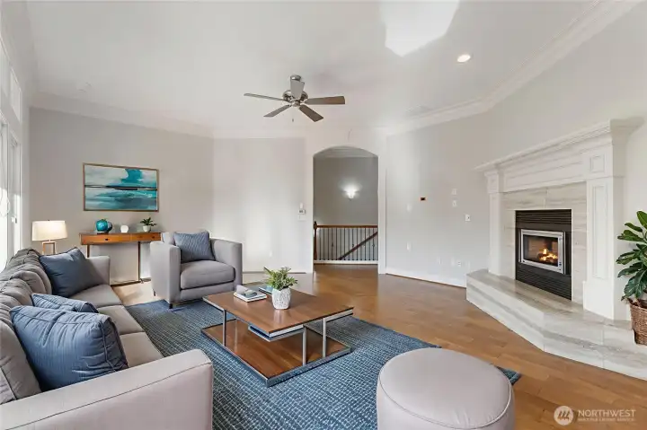 Spacious great room with fireplace with tile surround, wood floors, ceiling fan and more!