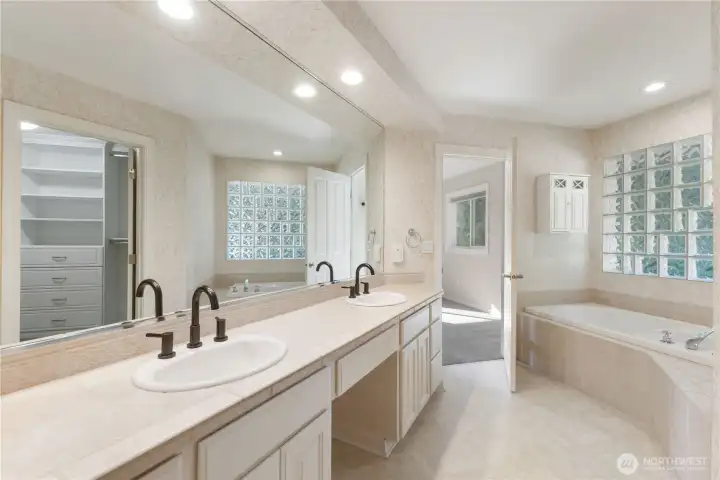 The primary bath features a large soaking tub, double sinks, tile work, walk-in shower with dual shower heads and bidet.